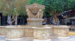 A stone fountain with intricate carvings and two lions at the top. - Casa di Cleopatra - Heraklion Luxurious Getaway (Heraklion)