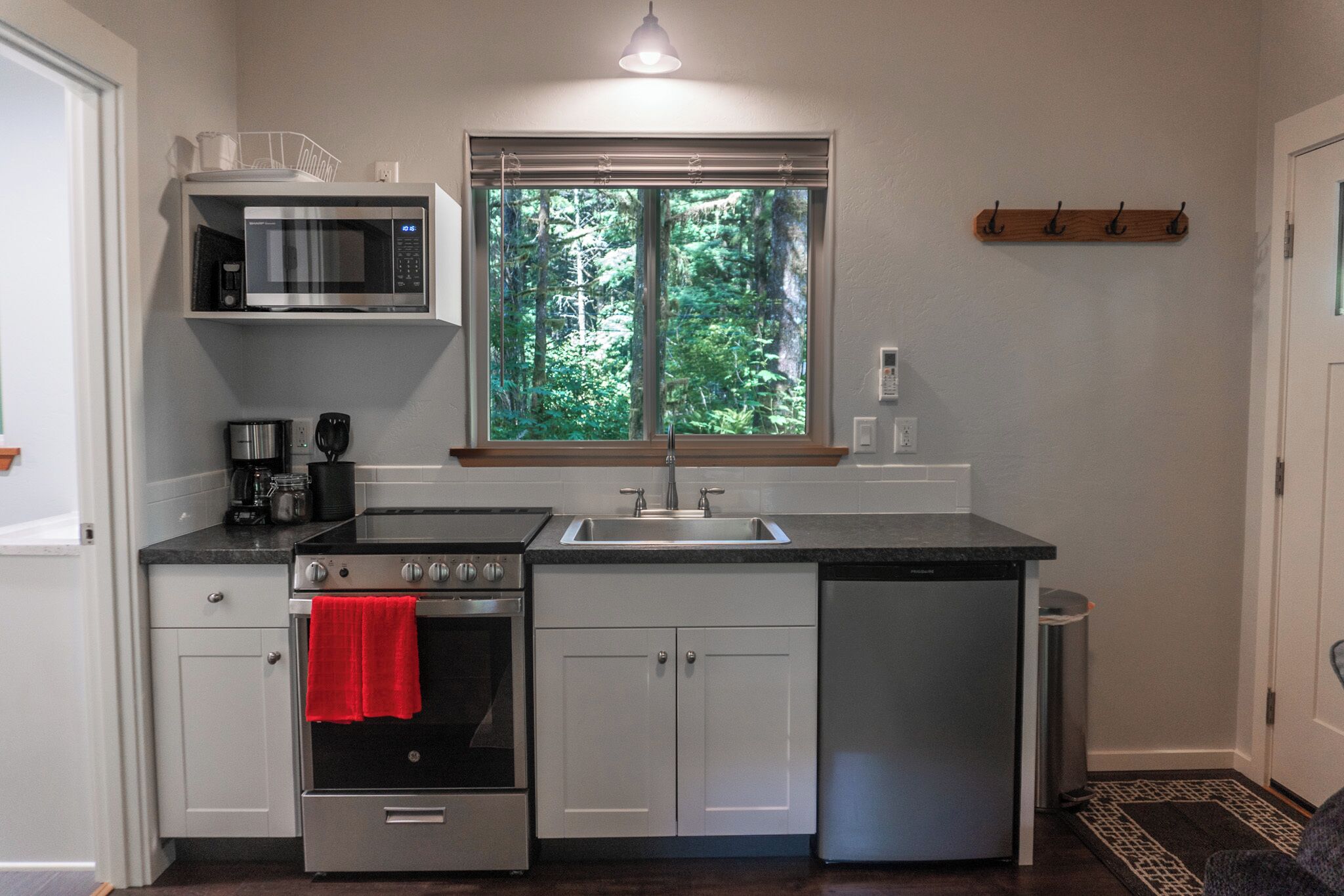A compact kitchen with a microwave, coffee maker, oven, and dishwasher.