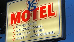 A motel sign listing amenities including kitchen units, air conditioning, direct dial phones, and cable TV. - Y5 Motel  (Barrière)