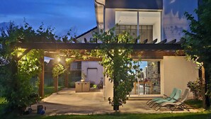A modern house with a covered patio, two lounge chairs, and a small table. - Escape to a Charming Villa in Haut-Doubs. (Bians-les-Usiers)