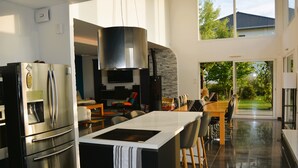 A modern kitchen with a large island, stainless steel appliances, and a view of the outdoors. - Escape to a Charming Villa in Haut-Doubs. (Bians-les-Usiers)