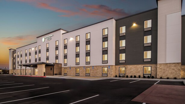 A modern hotel with a flat roof, multiple windows, and a parking lot. - Woodspring Suites Palmdale - Lancaster (Palmdale)