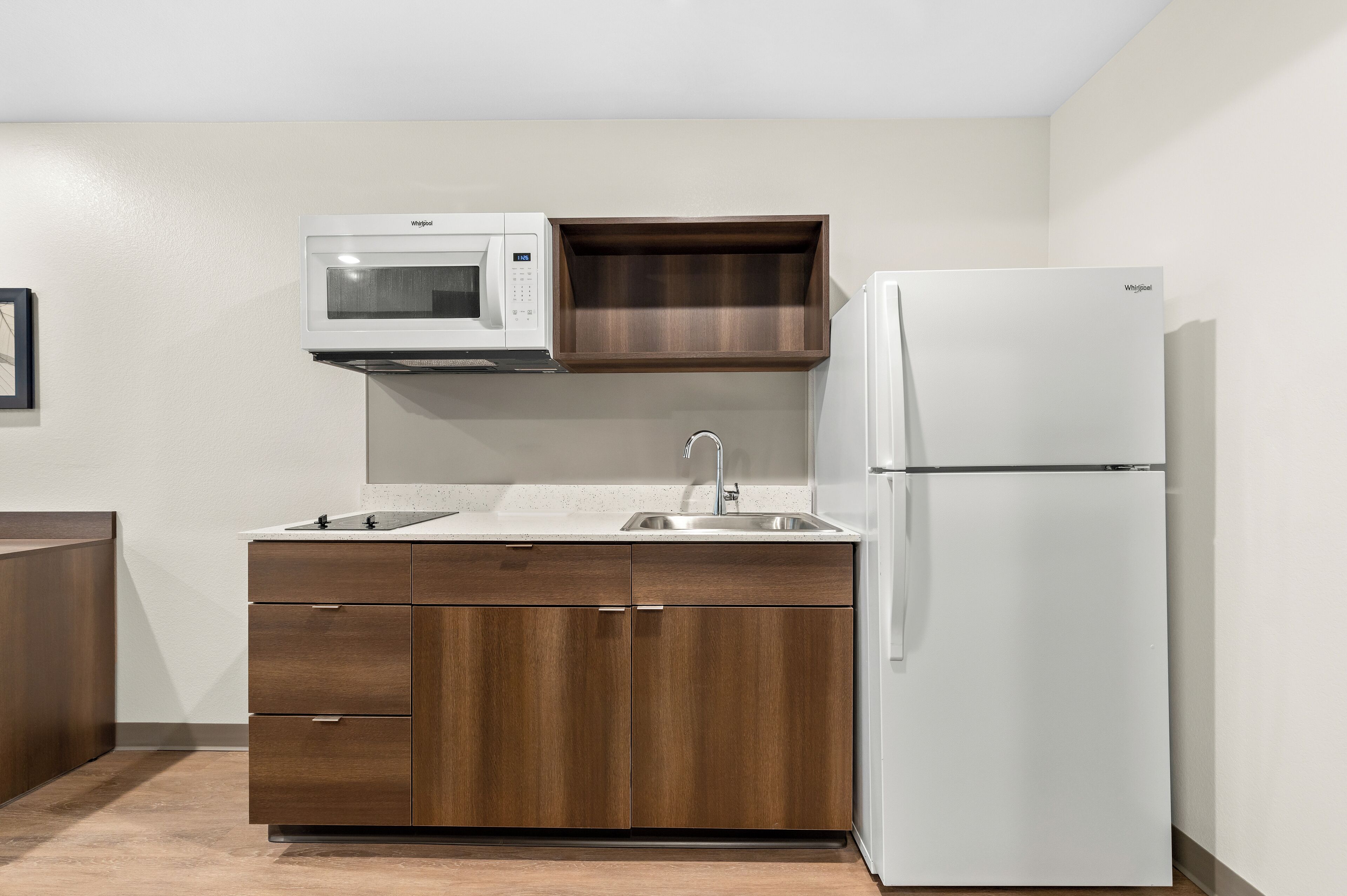 Una cocina compacta con microondas, fregadero y refrigerador.
