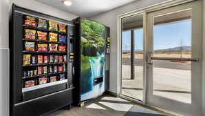 A vending machine with snacks and a digital screen displaying a waterfall. - Woodspring Suites Palmdale - Lancaster (Palmdale)