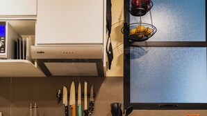 Una cocina con estufa, horno y un soporte para cuchillos.