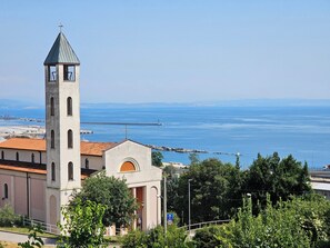 A church with a bell tower and a view of the sea. - Cozy rustical apartment with WiFi and AC in charming Rijeka (Rijeka)