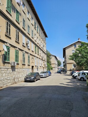 A street with parked cars and buildings with multiple windows and shutters. - Cozy rustical apartment with WiFi and AC in charming Rijeka (Rijeka)