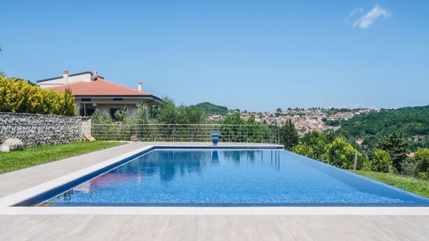 A swimming pool with a view of a town and hills in the background. - Villa in Vigna Apartment (San Mango sul Calore)