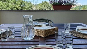 A table set outdoors with a clear view of trees and a blue sky. - Villa in Vigna Apartment (San Mango sul Calore)