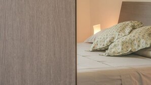 A bedroom with a bed, pillows, and a nightstand. - Villa in Vigna Apartment (San Mango sul Calore)