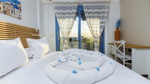Un dormitori amb un llit, escriptori, cadira i vistes a l'exterior.