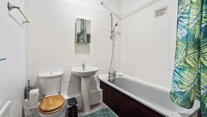 Een badkamer met toilet, wastafel en bad.