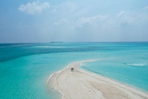 Ein Strand mit klarem türkisblauem Wasser und einem sandigen Ufer.