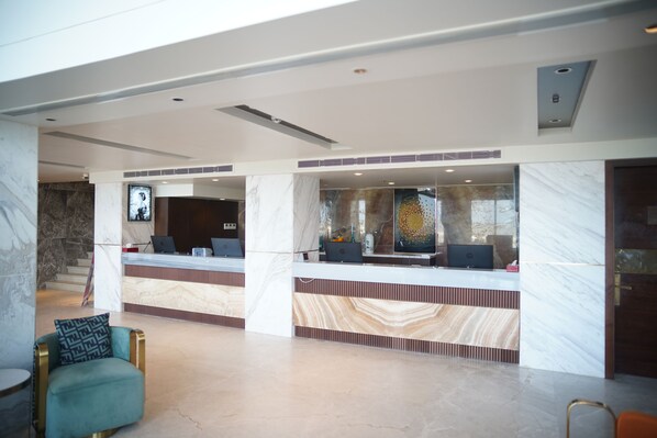 A modern reception area with marble counters, a reception desk, and seating.
