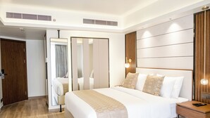 A modern hotel room with a large bed, a wooden nightstand, and a mirror. - Ramada by Wyndham Cox's Bazar Kolatoli Beach (Cox's Bazar)