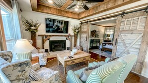 Ein gemütliches Wohnzimmer mit Kamin, Fernseher und Sofa.