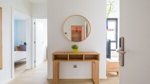 A hallway with a wooden console table, a mirror, and a potted plant. - VIVENTE 3A BY CANARIAS GETAWAY (Las Palmas de Gran Canaria)