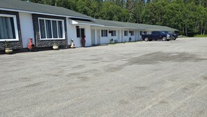 Une rangée de maisons mobiles de plain-pied, avec un espace de stationnement en gravier devant.