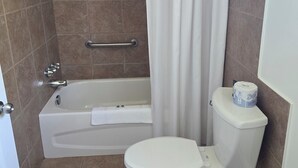 Une salle de bain avec une baignoire, des toilettes et un rideau de douche.