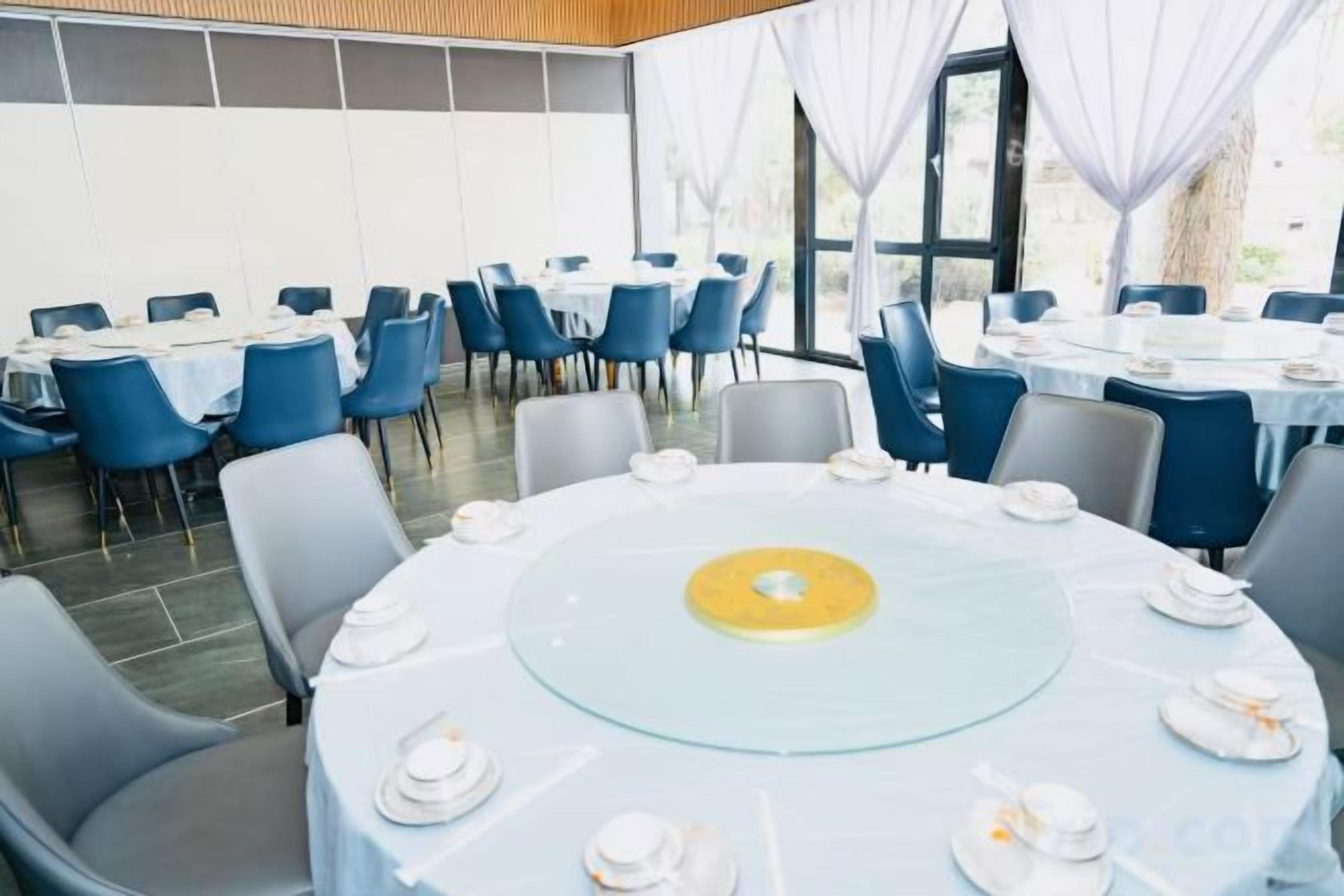 A conference room with round tables, chairs, and a glass table center.