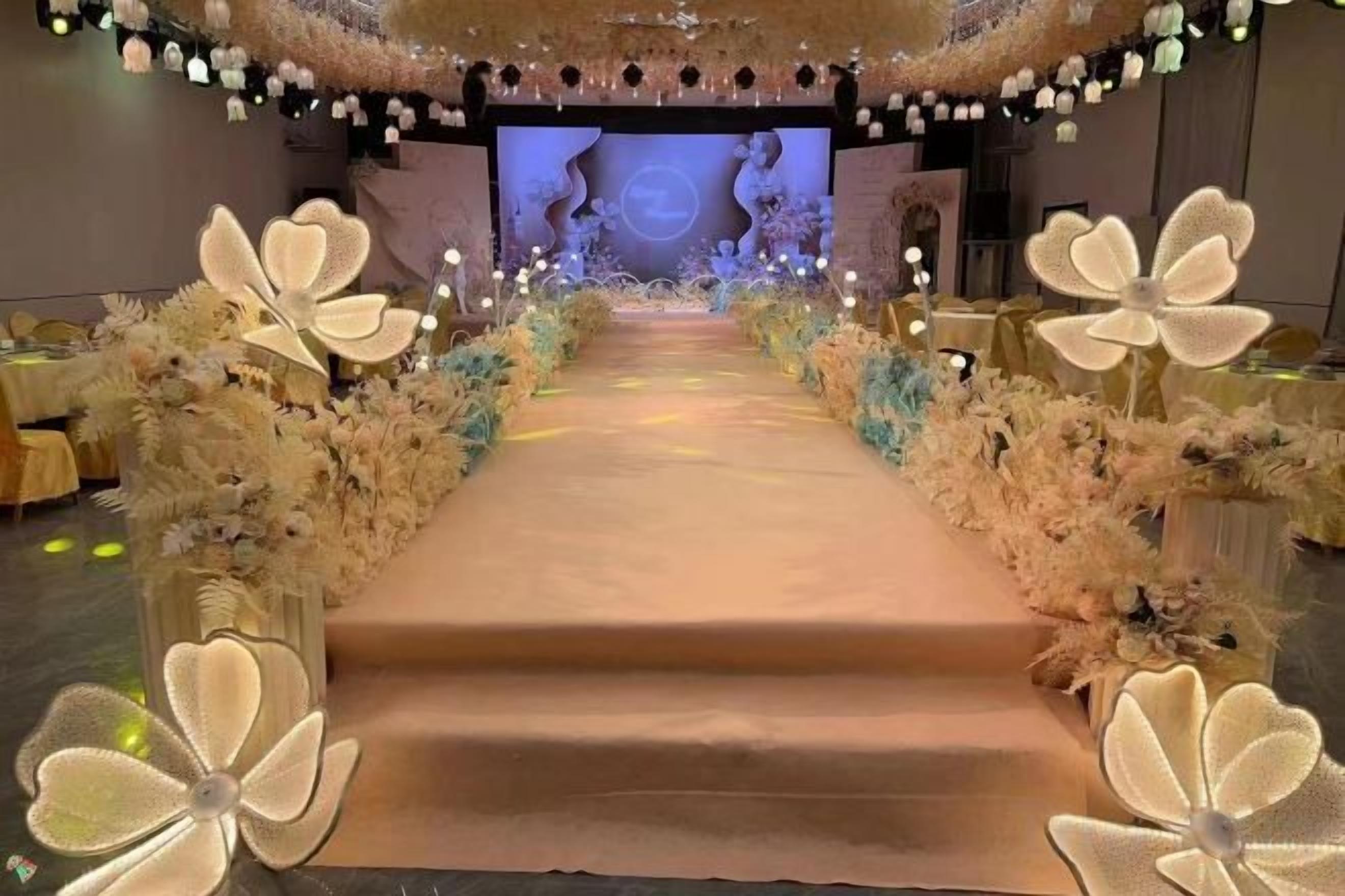 A stage with a long, narrow carpet leading to a screen displaying a woman's face.