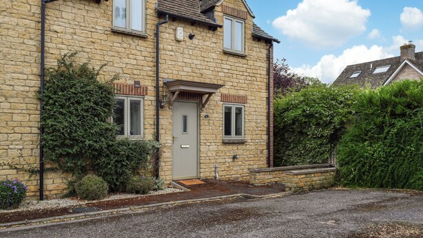 A two-story stone house with a grey door, two windows on the ground floor, and a small porch. - 2 bedroom accommodation in Eynsham (Eynsham)