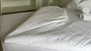 Un dormitorio con cama, armario empotrado y cama bien hecha con toallas enrolladas.