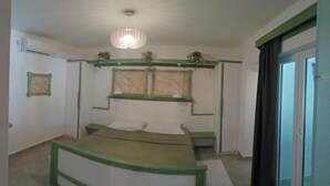 Un dormitorio con cama, ventana, luz de techo y puerta.