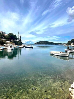 Ein Yachthafen mit vertäuten Booten, klarem Wasser und einer hügeligen Landschaft im Hintergrund.