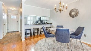 A modern kitchen with white cabinets, a central island, and a chandelier. - Mobile Townhome Near University of South Alabama! (Mobile)