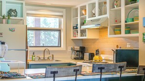 Una cocina con isla integrada, refrigerador, pileta y ventana.