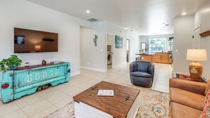 A spacious living room with a television, a coffee table, a sofa, and a unique turquoise vintage truck as a coffee table. - Walk to Flagstaff Urban Trails System: Cozy Home (Flagstaff)