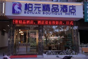 A hotel entrance with a sign indicating it's a boutique hotel. - Pu'erbaiyuan Boutique Hotel (Pu'er)