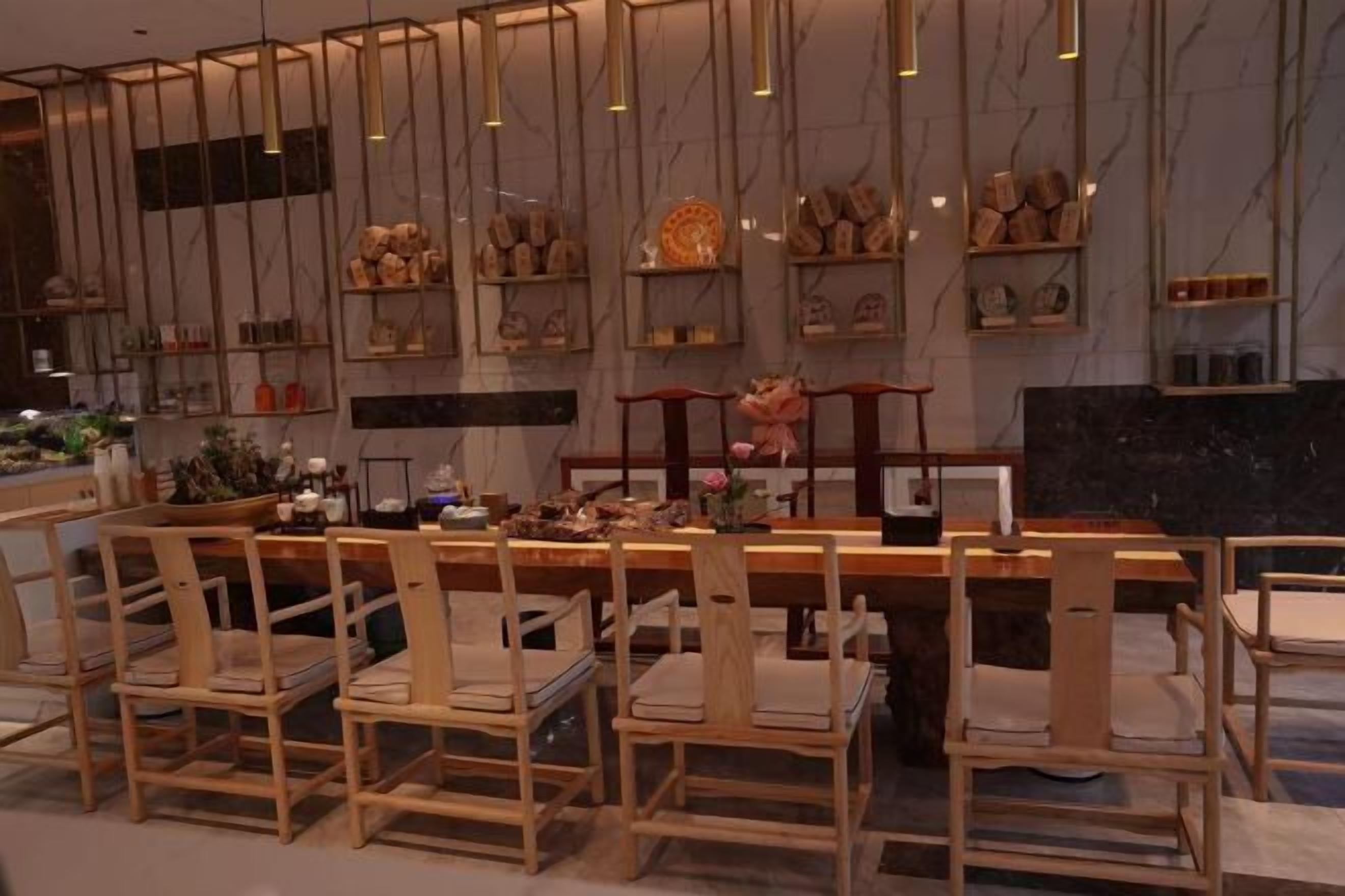 A restaurant with wooden chairs and a marble wall.
