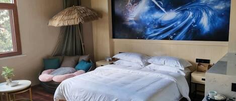 A bedroom with a large bed, a nightstand, a wall art depicting a cosmic scene, a window, and a small round table with a plant.