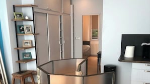 A modern kitchen with a central island, wooden flooring, and a built-in bookshelf with framed photos. - Loft 2 BR Loft Effeil tower AC by LCC Agency (Paris)