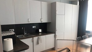 A modern kitchen with white cabinets, a black countertop, and a stainless steel sink. - Loft 2 BR Loft Effeil tower AC by LCC Agency (Paris)