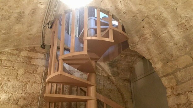 A spiral staircase in a stone-walled room. - Loft 2 BR Loft Effeil tower AC by LCC Agency (Paris)