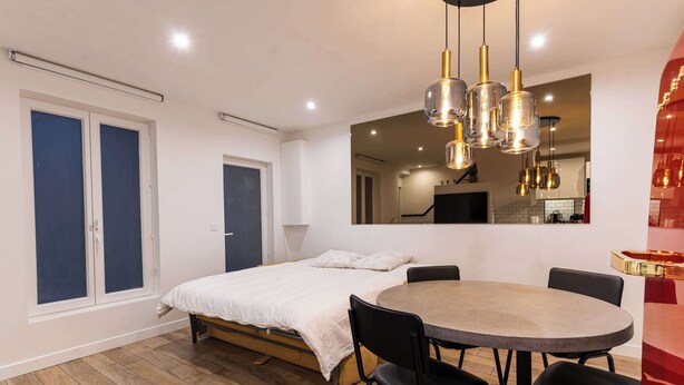 A bedroom with a bed, a round dining table with chairs, and a large mirror. - Town House Nation, Bastille, AC by LCC Agency (Paris)
