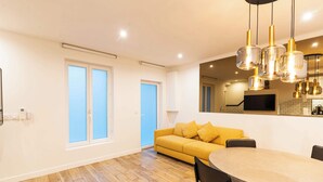 A modern kitchen with a yellow sofa, a dining table, and pendant lighting. - Town House Nation, Bastille, AC by LCC Agency (Paris)