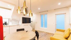 A modern kitchen with white cabinets, a built-in TV, and pendant lighting. - Town House Nation, Bastille, AC by LCC Agency (Paris)