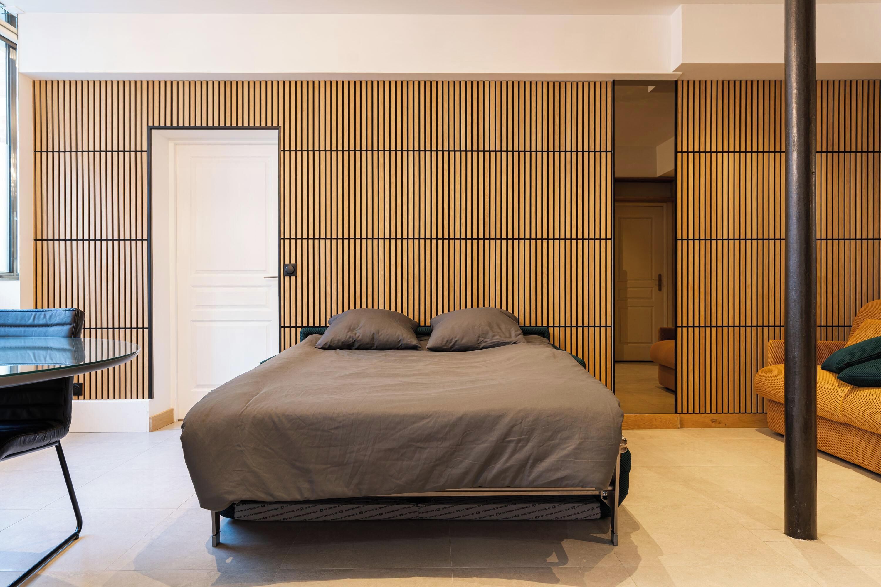 Une chambre à coucher moderne avec un lit, une chaise et un canapé.
