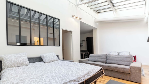 Et moderne soveværelse med en stor seng, en sofa og en bænk.