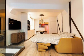 A modern bedroom with a large bed, a glass partition, a wooden cabinet, and a television on the wall. - Loft 1 BR Marais, Notre Dame AC by LCC Agency (Paris)