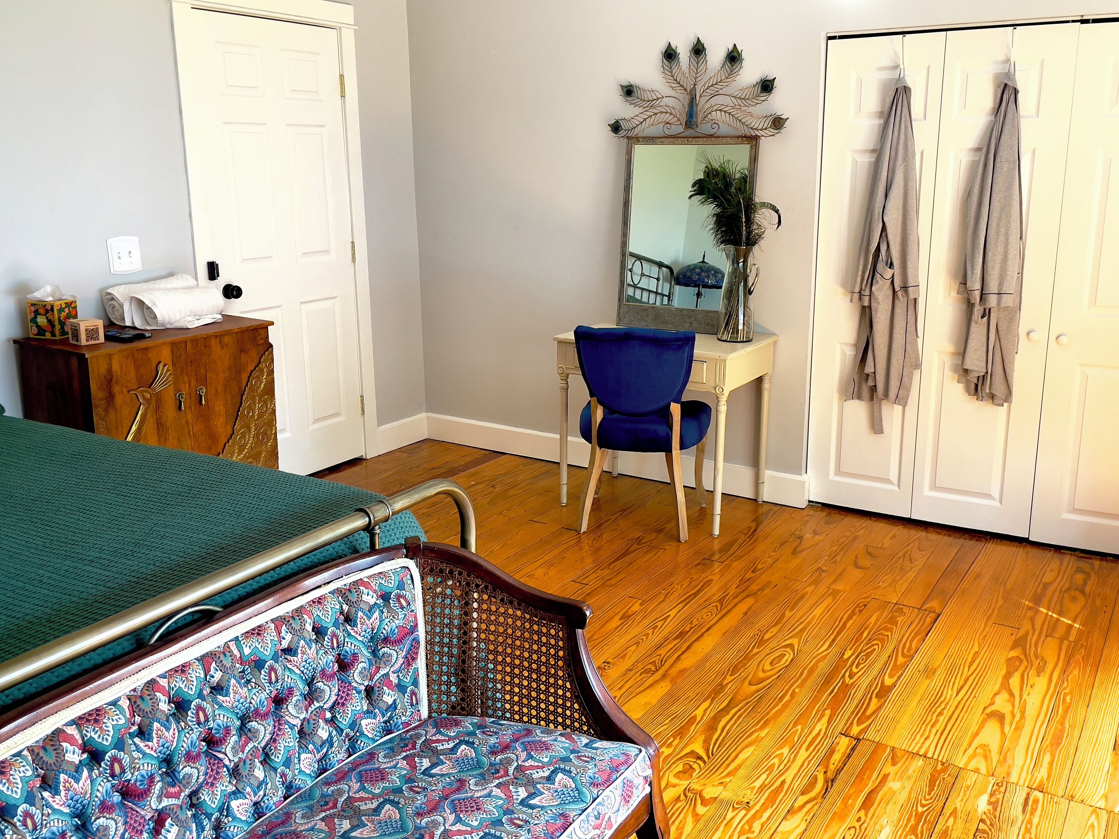 A room with a bed, a desk, a chair, and a wardrobe.