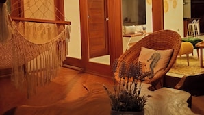 A spacious room with a hammock, a wicker chair, and a potted plant. - Galapagos Coliving Ecuador Casa Tuna (Puerto Ayora)
