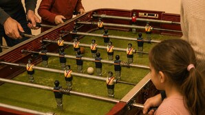 A foosball table with players and a ball in a room with beige walls and electrical outlets. - Buenos Aires de Ezeiza Resort Vacacional - Departamento N°1 (La Unión)