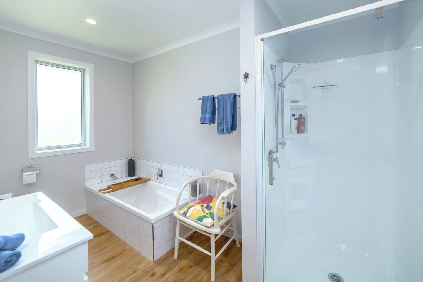 A bathroom with a bathtub, a shower, a toilet, and a window.