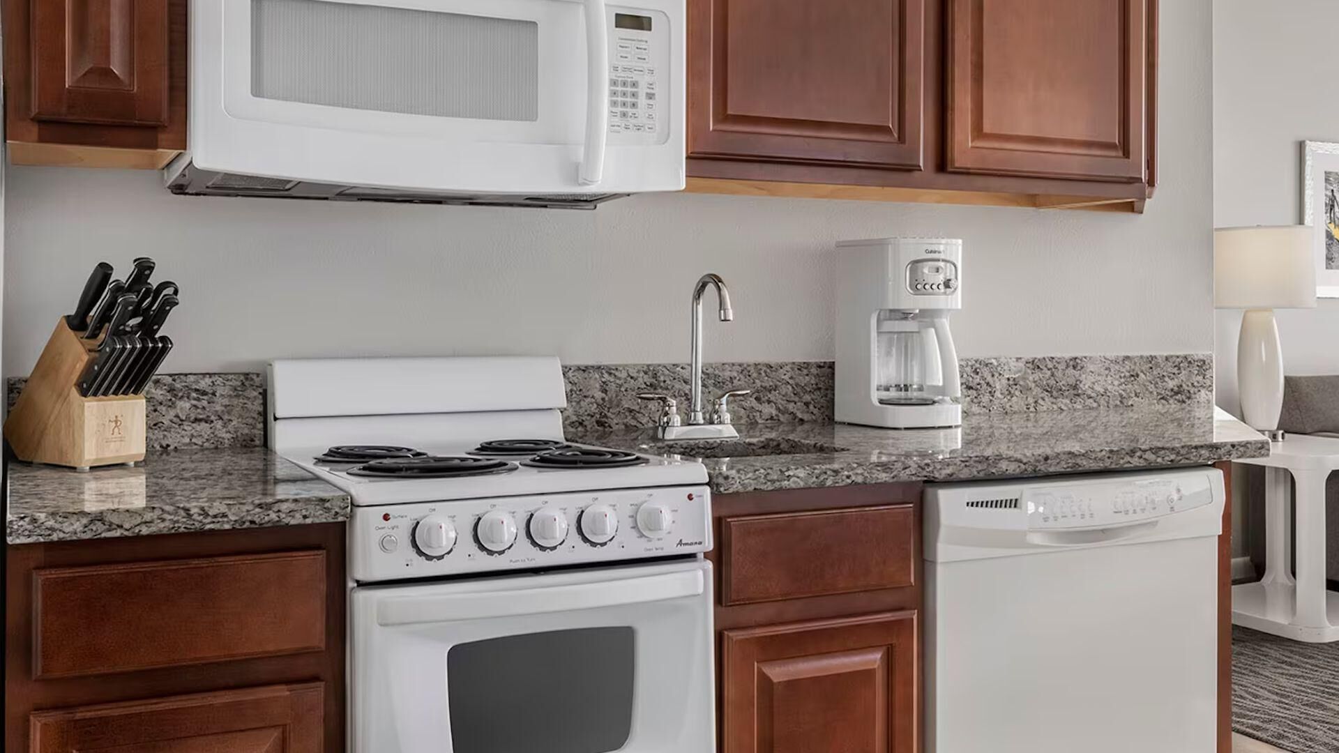 A kitchen with a stove, microwave, coffee maker, and dishwasher.