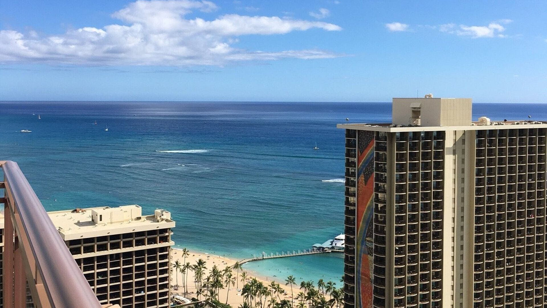 A high-rise hotel with a view of the ocean and beach.